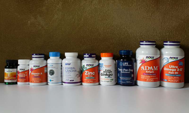 Close-up of diverse probiotic supplement capsules arranged on a clean white surface with fresh ginger and yogurt — symbolizing gut-friendly nutrition and microbiome support